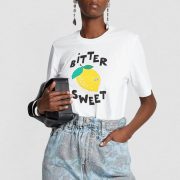 white tshirt with graphic lemon print and bitter sweet writing with a handbag and jeans